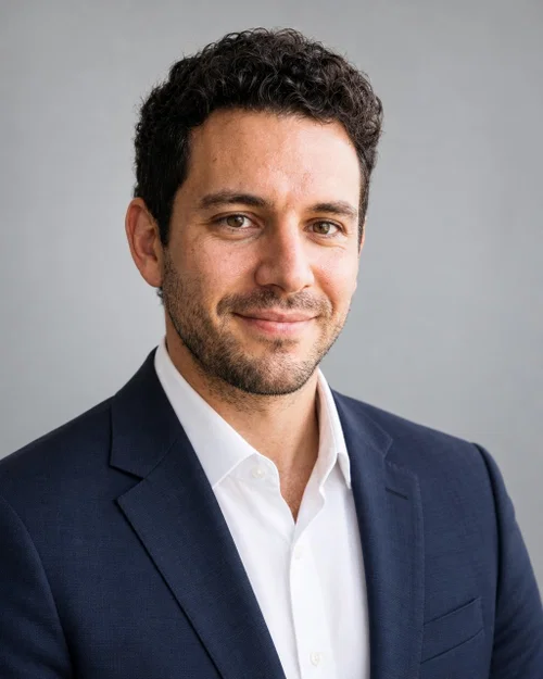 AI corporate headshot in a navy suit and white shirt on a light grey studio background